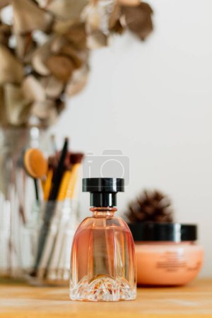 Photo for Aesthetic minimalist beauty composition with bottle of perfume, makeup brushes and eucalyptus branches on background - Royalty Free Image