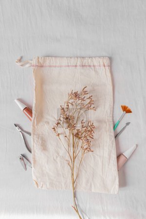 Téléchargez les photos : Blog beauté, concept de manucure avec vernis à ongles, sac en coton et outils de manucure décorés de fleurs lilas - en image libre de droit