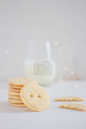 Photo for Button shaped handmade vanila cookies and glass of milk on white background. Flat lay, top view. - Royalty Free Image