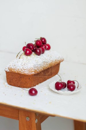 Téléchargez les photos : Gâteau aux noix fait maison avec cerises sur fond blanc. Concept de petit déjeuner esthétique. - en image libre de droit