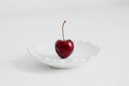 Téléchargez les photos : Cerises sur un bol, sur fond blanc. Composition minimaliste. - en image libre de droit
