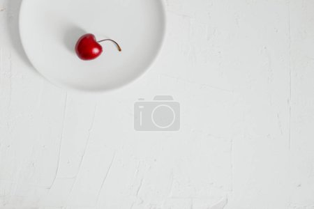 Téléchargez les photos : Cerises sur un bol, sur fond blanc. Composition minimaliste. - en image libre de droit
