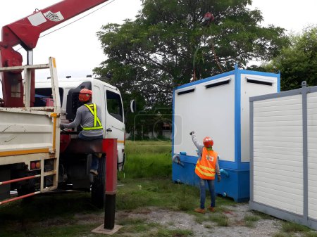 Téléchargez les photos : Les camions-grues transportent les toilettes mobiles pour l'installation dans la zone du chantier, la mobilisation du projet. - en image libre de droit