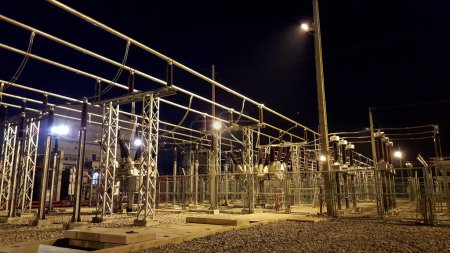 Foto de Patio de distribución: Subestación con aislamiento de aire y equipo de conmutación híbrido durante la noche - Imagen libre de derechos