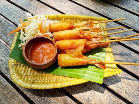 Photo for Crispy shrimp spring rolls with sweet sauce on a wooden table. - Royalty Free Image