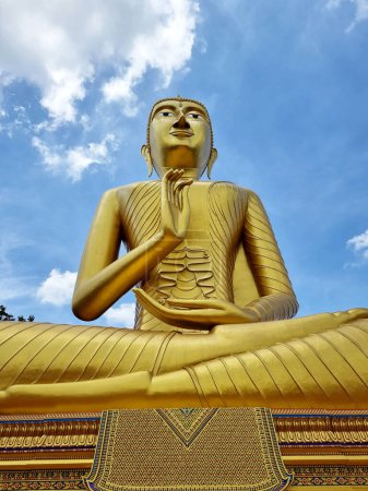 Foto de Luang Pho Yai, una imagen masiva de Buda en postura de bendición sobre el fondo azul del cielo. en el templo de Wat Phrathat Wayo, subdistrito de Lat Krathing, distrito de Sanam Chai Khet, Chachoengsao, Tailandia - Imagen libre de derechos