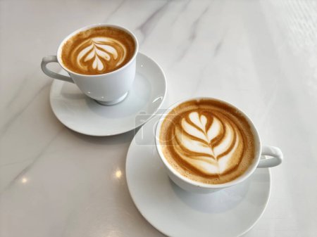 Photo for Two cups of hot latte art tulip coffee - Royalty Free Image