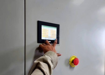 Foto de El ingeniero eléctrico presionó el monitor para el inversor de energía de la granja solar. - Imagen libre de derechos