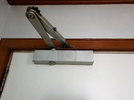 Door closer : A manual door closer stores the energy used in the opening of the door in a compression or torsion spring and releases it to close the door