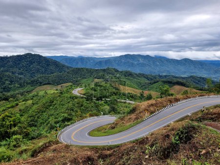 Routes flottantes avec des collines luxuriantes et un ciel bleu avec des nuages de nimbus, dans la province de Nan, Thaïlande