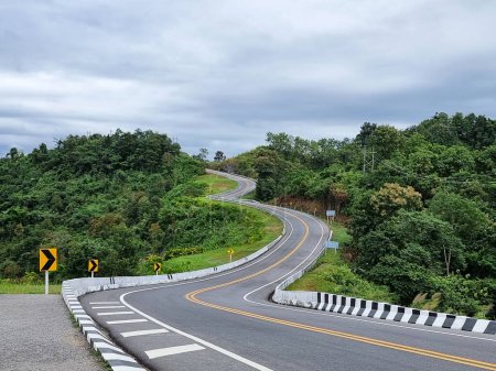Eine schöne Aussicht Nans Road, die Kurve der Straße bildet die Form der Nummer drei mit üppigen Hügeln und blauem Himmel mit Wolken, in der Provinz Nan, Thailand