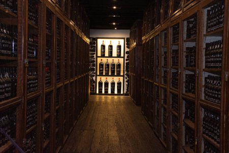 Weinkeller-Interieur mit Weinflaschen in Regalen hintereinander, Stadt Funchal auf Madeira, Portugal