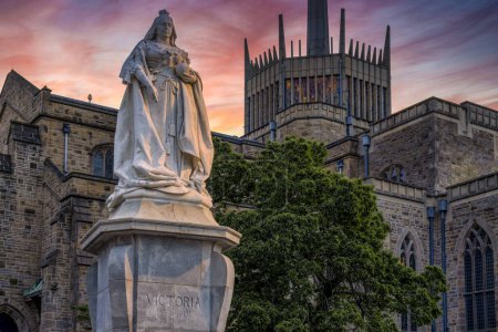 Téléchargez les photos : Cathédrale Blackburn avec statue de la reine Victoria au coucher du soleil. La statue est un monument classé Grade II situé à Blackburn, Lancashire, Royaume-Uni. - en image libre de droit