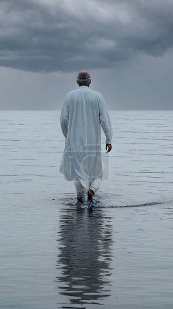 sea, bay, shores are visible, a man in long white clothes walks on the surface of the water