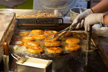 hotteok, Korean Syrup-filled Pancake : Fermented flour dough shaped into balls, filled with a spoonful of brown sugar, and pan-fried in a preheated pan. Brown sugar mixed with cinnamon powder is a com