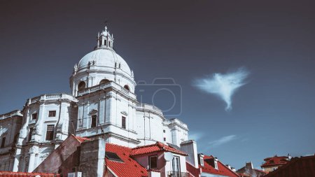 Téléchargez les photos : Vue sur l'église de Santa Engracia ou un autre nom Panthéon national journée froide, avec un ciel bleu profond et un nuage unique sous la forme d'un ange à côté du dôme et les toits rouges des maisons - en image libre de droit