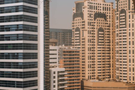 Foto de Vista de cerca desde lo alto sobre las fachadas de enormes rascacielos residenciales; elevaciones de rascacielos de vivienda en un día brillante - Imagen libre de derechos
