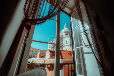 Foto de Un plano de gran angular de un día soleado con un cielo despejado desde una habitación de apartamentos con vistas a los edificios antiguos de la ciudad de Lisboa, y el Panteón Nacional en la iglesia de Santa Engracia, en el fondo - Imagen libre de derechos
