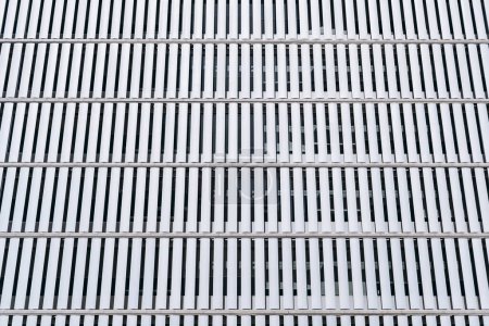 Téléchargez les photos : Façade ultra-moderne d'un bâtiment dans un motif séquentiel de plaques rectangulaires blanches en métal qui préservent l'intimité à l'intérieur du bâtiment et lui permettent de recevoir la lumière du soleil à l'intérieur - en image libre de droit
