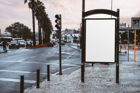 Téléchargez les photos : Blank placard mockup next to a traffic light beside a wide road; an empty advert billboard template in a small town; a white advertisement banner placeholder in an urban setting near Estoril, Portugal - en image libre de droit