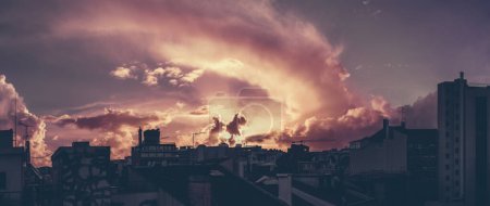 Photo for A panoramic shot of a dramatic sunset in Lisbon with silhouettes of residential and office houses; the panorama of stunning evening cloudscape over the cityscape with purple colour tint - Royalty Free Image