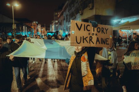 Téléchargez les photos : Lisbonne, Portugal - 24 février 2023 : Une scène discrète de manifestants debout dans la nuit, une présence puissante au milieu de la manifestation anti-guerre marquant un an depuis le début du conflit ukrainien - en image libre de droit