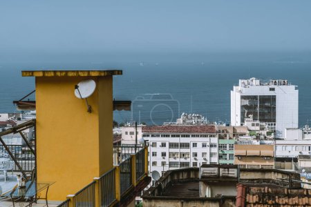 Téléchargez les photos : D'un appartement de grande hauteur à Rio de Janeiro, au Brésil, la vue montre une mer sereine et des bâtiments environnants, certains apparaissant vieux et délabrés - en image libre de droit