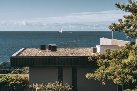 Photo for Nestled among pine trees with the tranquil sea in sight, this contemporary architecture house in Estoril, Portugal, boasts a striking cuboid geometry and a unique shallow gravel roof - Royalty Free Image