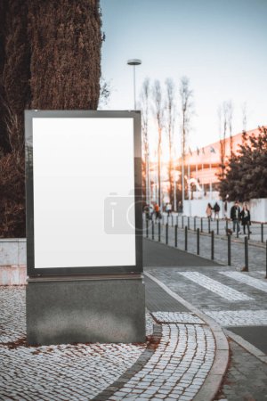 Foto de Lisboa; Una maqueta vertical para un anuncio, con una cartelera vacía blanca en el centro de la acera junto a un cruce de cebra, ofrece un amplio espacio para anuncios personalizados. - Imagen libre de derechos