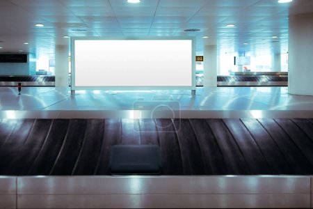 Photo for Lisbon; Luggage claim area; Circular conveyor belt featuring a large white blank mockup at its center. The grey-toned surroundings are impeccably illuminated with bright white lights, very modern - Royalty Free Image