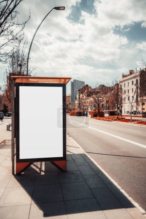 Téléchargez les photos : Un plan vertical d'un arrêt de bus contemporain à Barcelone avec une maquette vierge d'une bannière publicitaire ; une route asphaltée avec une station de transport moderne et un gabarit de panneau publicitaire vide - en image libre de droit