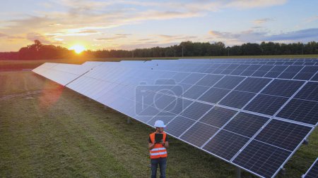 Photo for Aerial view of a technician testing photovoltaic panels during regular maintenance - Royalty Free Image