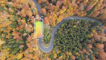 Photo for Electric car on curved autumn road with graphic of battery indicator. Aerial - Royalty Free Image