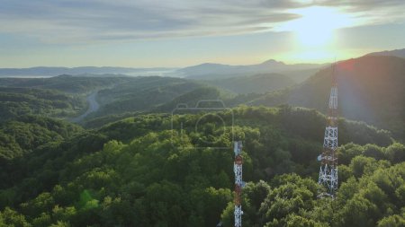 Photo for Aerial view of 4G and 5G Telecom Tower on the top of hill covered of green forest during golden hour - Royalty Free Image