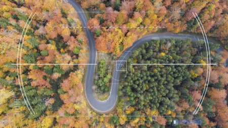 Foto de Vista aérea del coche de seguimiento en una carretera curvilínea en medio del bosque en colores de hoja de otoño. Vehículo de Apuntar Gráficos, Aéreo - Imagen libre de derechos