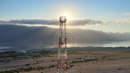 Aerial view of 5G 6G futuristic technology power telecom station in a remote area with stunning ocean view and Sunrays. Smart city artificial intelligence concept