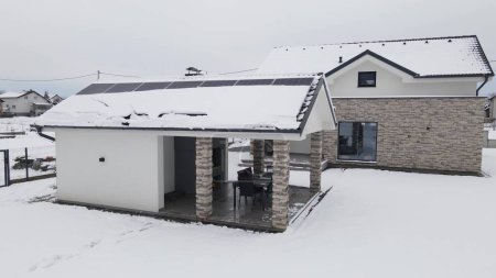 Smart Home With No Electricity Due To Snowstorm. Solar Panels On Roof Covered By Snow In Winter