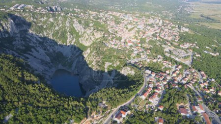 Luftaufnahme des Blauen Sees Plavo jezero und der Stadt Imotski im sonnigen Kroatien