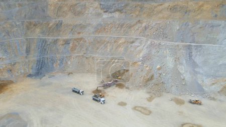 Sitio minero de cantera, trabajo industrial despejando escombros roca en foso, vista aérea