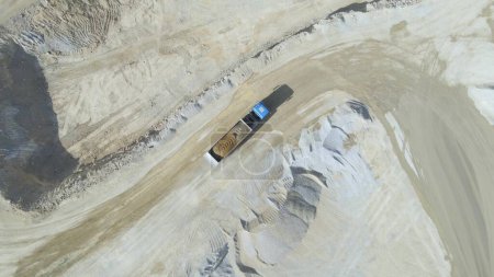 Top-Down-Drohne über einem mit Steinen beladenen Lastwagen auf Steinbruchgelände abgeschossen