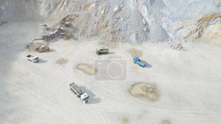 Heavy Machines and Loading Trucks in Stone Quarry. Transporting Gravel and Sand. Aerial