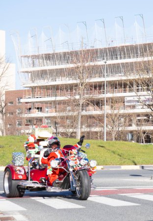 Téléchargez les photos : Père Noël, Père Noël à Can Am avec des croix cadeaux au passage pour piétons vélo rouge - en image libre de droit
