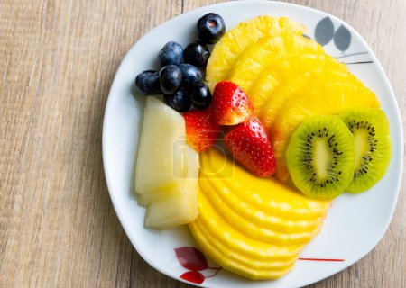 Photo for Photography of fresh fruit plate, with kiwi, pineapple, pineapple, melon, strawberries, mango, blueberries. new year, new life. - Royalty Free Image