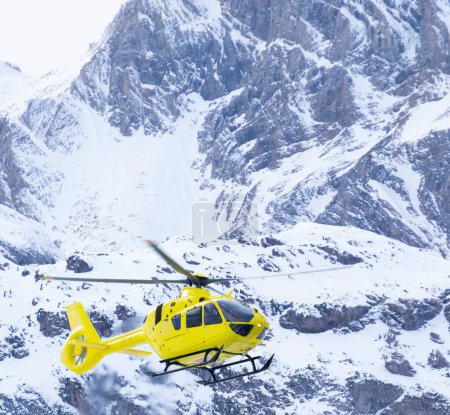 Foto de Helicóptero de rescate aterrizando en las montañas nevadas del Pirineo. Espacio de copia de aviones . - Imagen libre de derechos