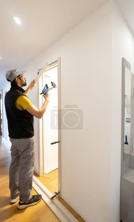 Ein professioneller Handwerker, Schreiner, der Türrahmen mit Klemmen aufstellt. Reparatur und Installation