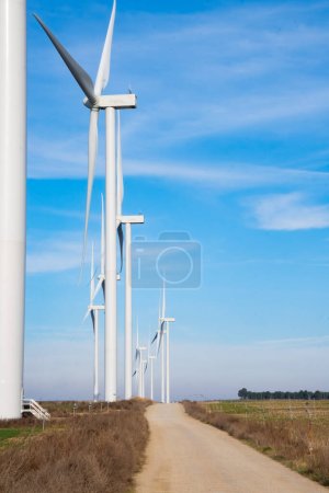 Pathway to Green Energy: Wind Turbines Alongside Rural Road.