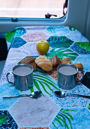 Téléchargez les photos : Petit déjeuner dans le camping-car tasses de café avec muffins et biscuits mode de vie alternatif. - en image libre de droit