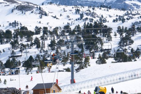Skihang Sessellift und transparenter Tunnel im Skigebiet Arette, Frankreich. mit Skifahrern und Snowboardern