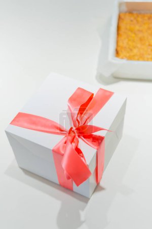 Gift-Ready Delight: A Cake in Its Box with a Scrumptious Sponge Cake Beside.