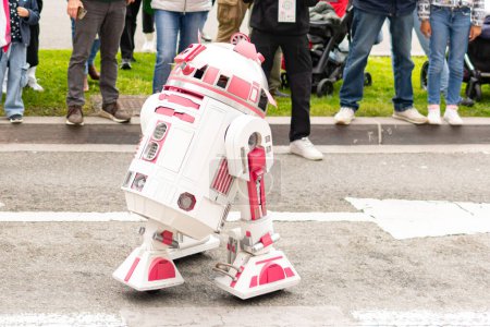 Photo for 2- R2D2 robot on the street in the road. Rounding up of people. pink color help cancer. - Royalty Free Image